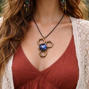 The Bohemian necklace features a unique Zen figure made of wood and fused blue g